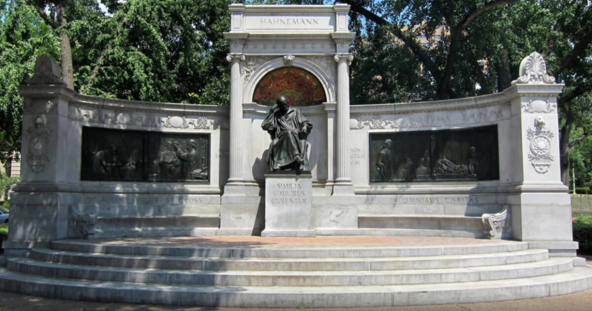 Memorial de Samuel Hahnemann, em Washington, D.C., nos Estados Unidos, com estátua central e relevos em pedra cercados por árvores.