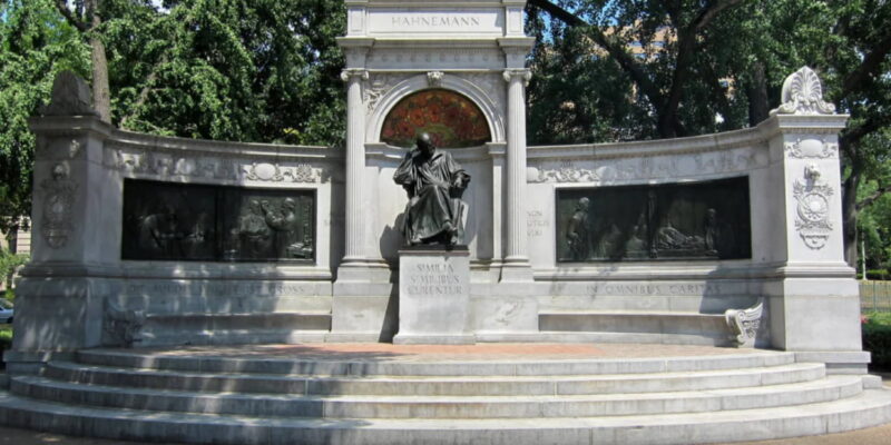 Memorial de Samuel Hahnemann, em Washington, D.C., nos Estados Unidos, com estátua central e relevos em pedra cercados por árvores.
